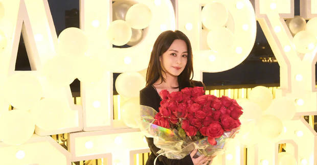 阿娇穿吊带裙，捧着玫瑰花束拍照，十分俏丽多姿！
