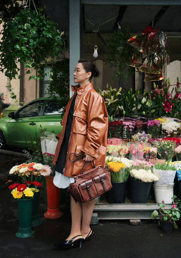 贾玲现身花摊前，棕皮衣造型超有氛围感。