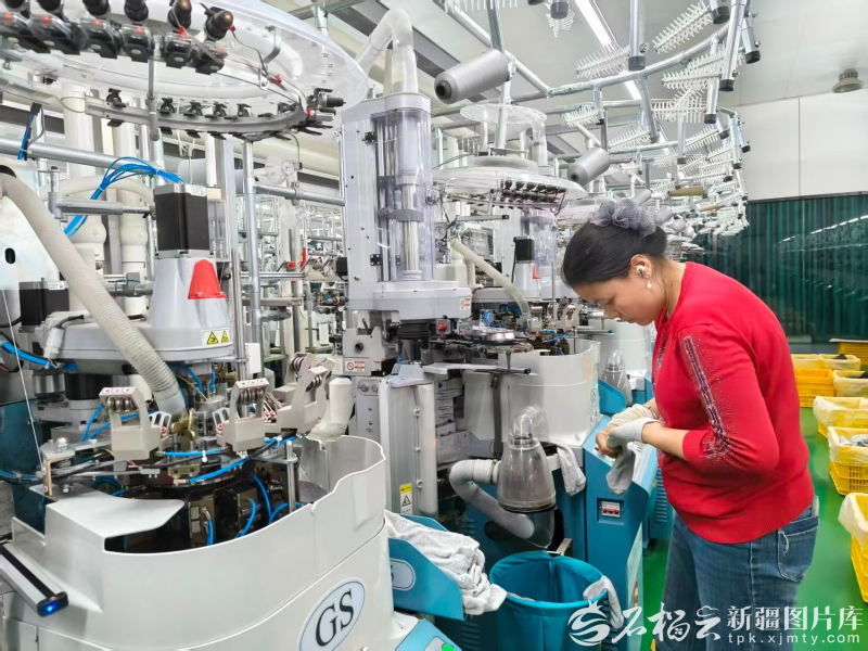 2025年10月20日,位于阿瓦提县工业园区的新疆集智纺织有限公司生产车间内,实现就近就业的农民在织袜生产线上作业。张卜龙摄