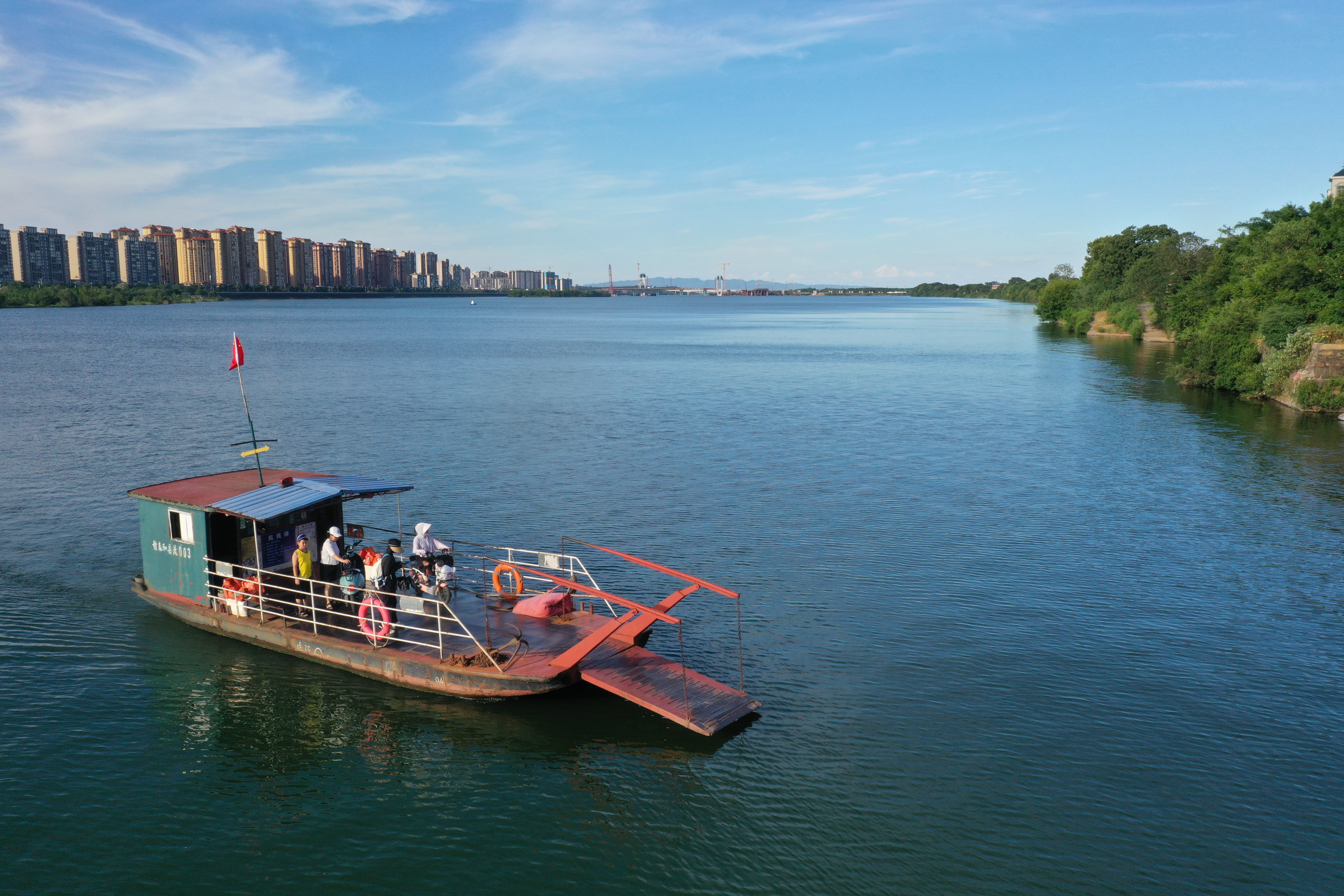 ▲2024年7月17日,泰和县永昌渡口的渡船横渡赣江。远处,澄江大桥正在建设中。
