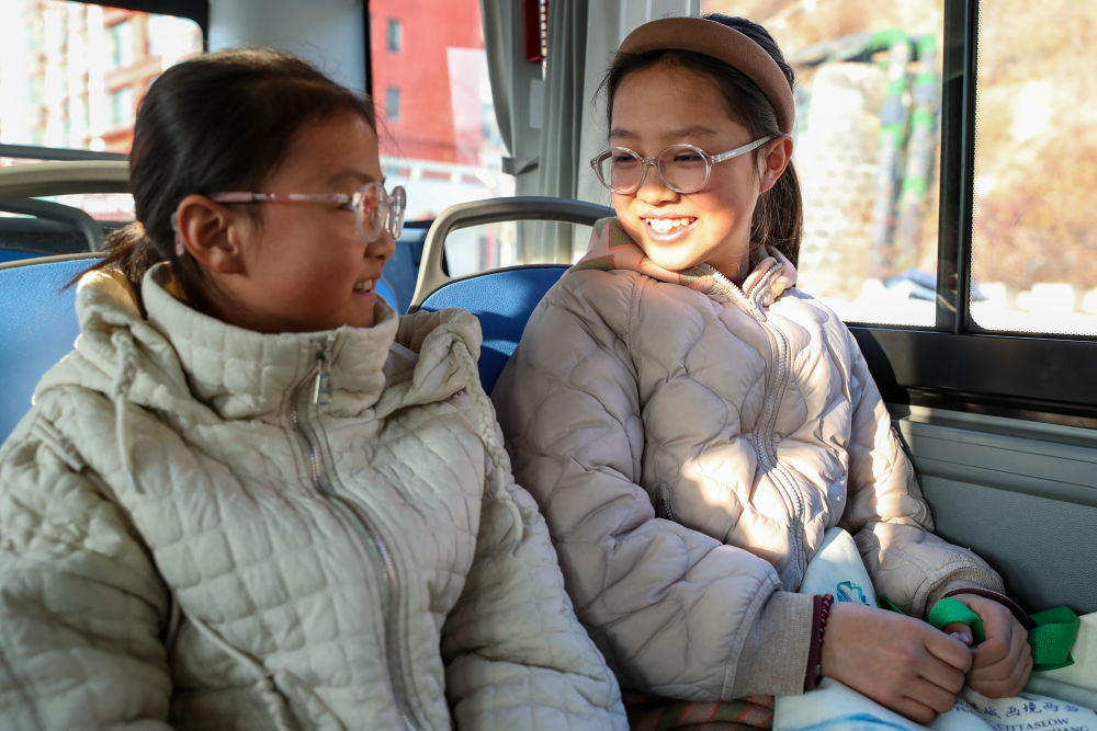 1月17日,在甘肃省陇南市两当县,2名学生乘坐免费公交出行。新华社记者 郎兵兵 摄