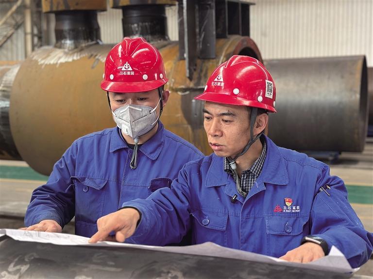 蔡明远(右)与同事分析图纸