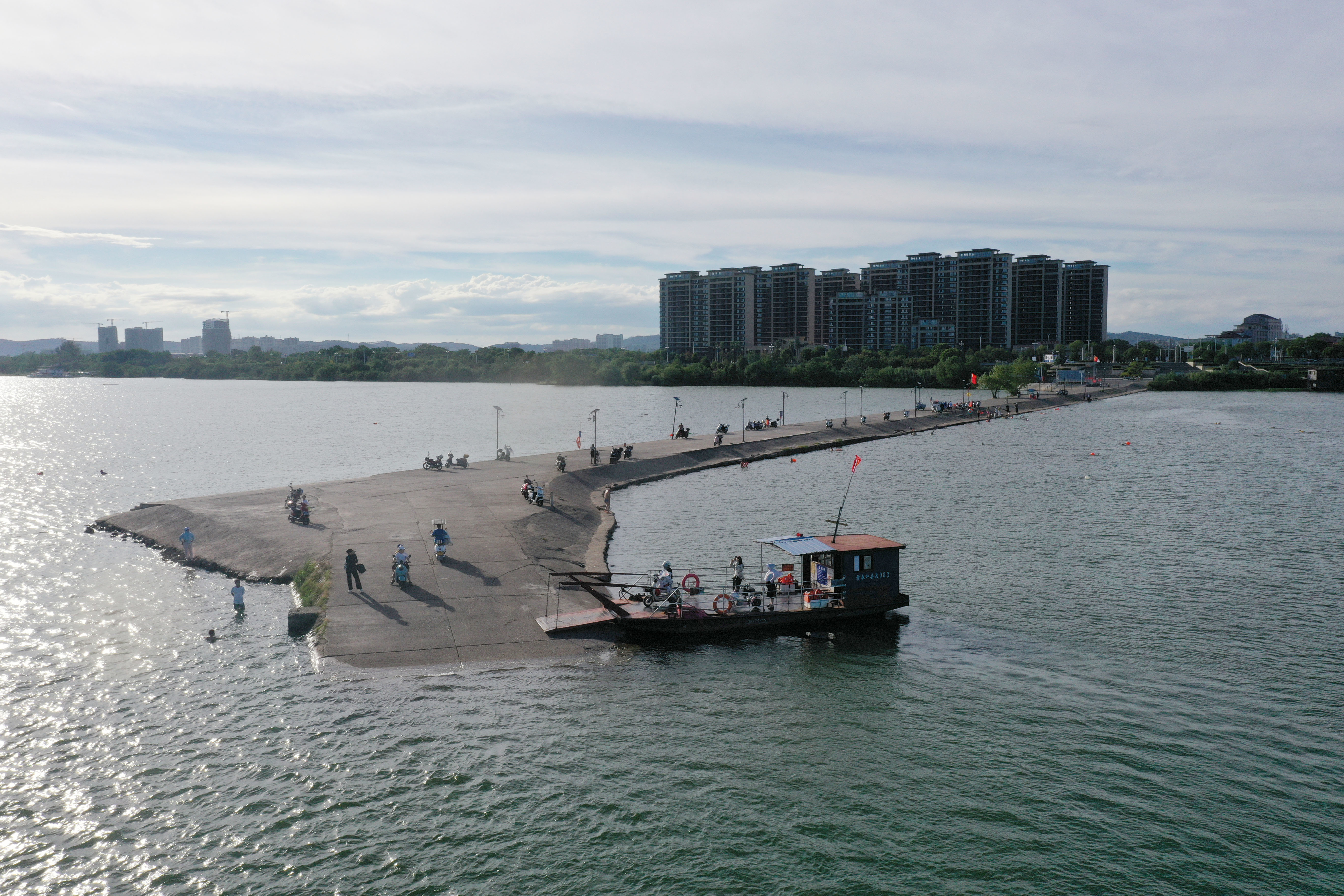 ▲2024年7月17日,泰和县县城南门,乘客从永昌渡口登上渡船。