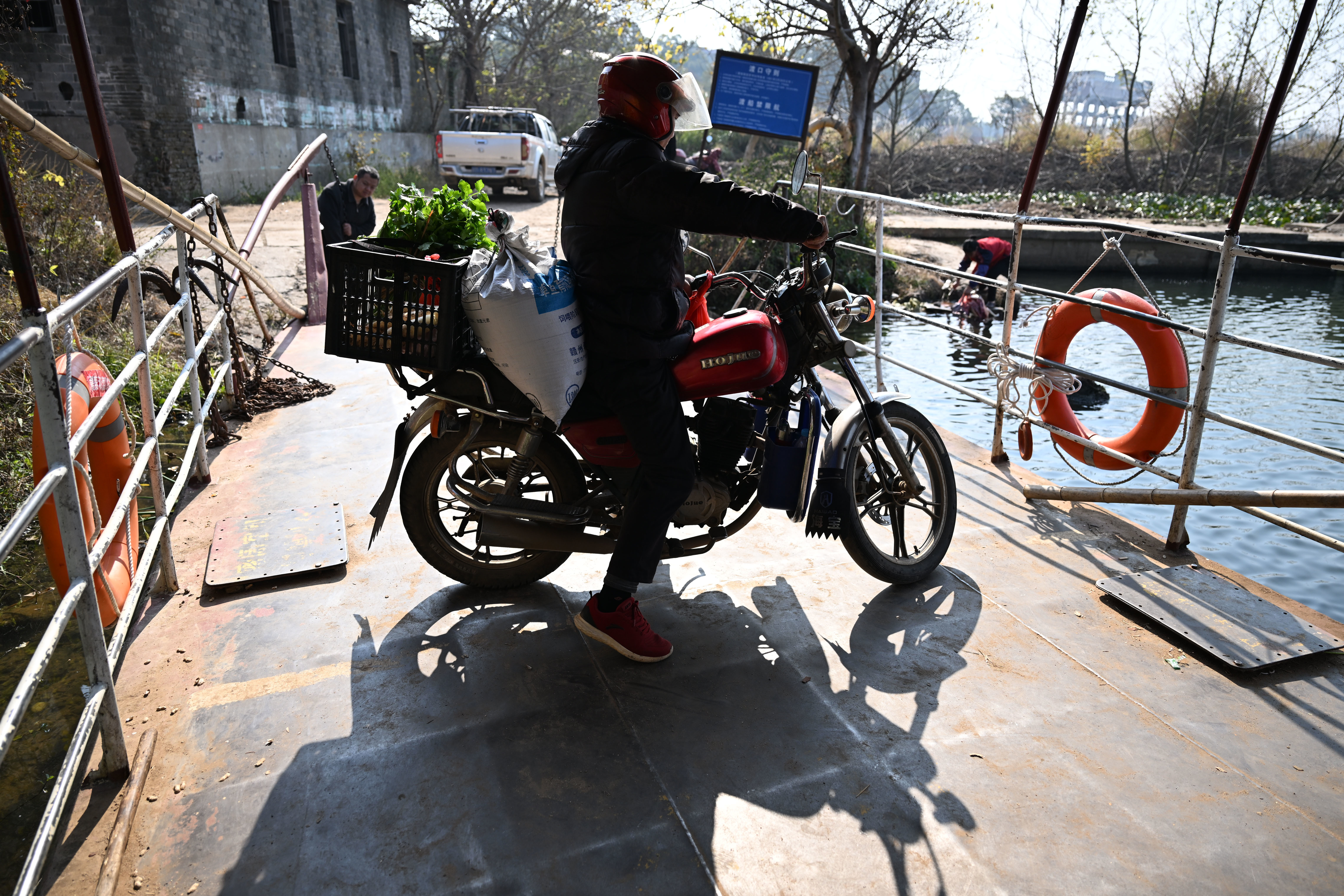 ▲泰和竹山渡口,赶集回来的村民骑车上船。