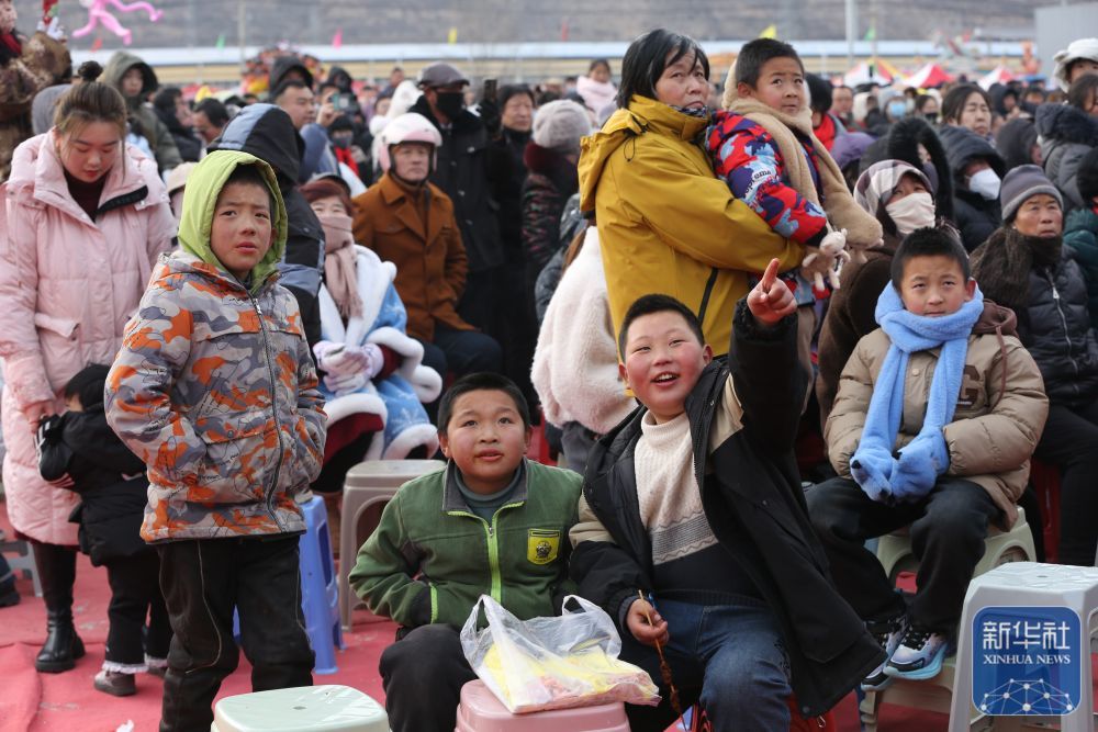 几位小朋友在年货大集上观看秦腔非遗演出(1月19日摄) 新华社发 王克贤 摄