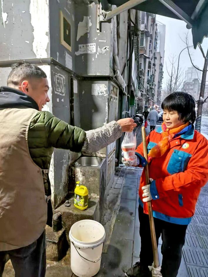 早餐店老板送热豆浆给环卫工