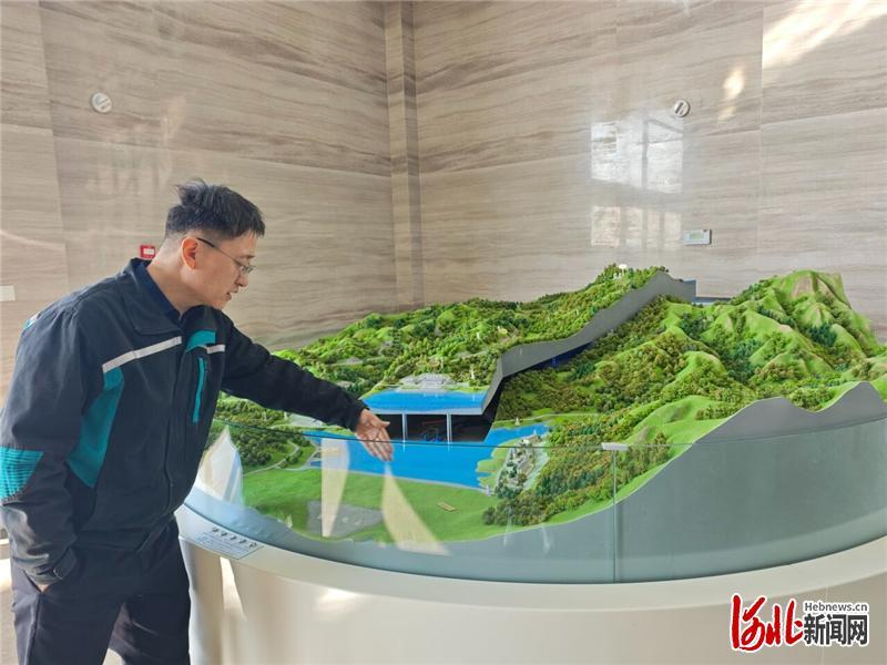 1月12日,国网新源河北易县抽水蓄能有限公司机电部主任侯录江在等比例模型前介绍易县抽水蓄能电站构造。 河北日报记者 王思达摄