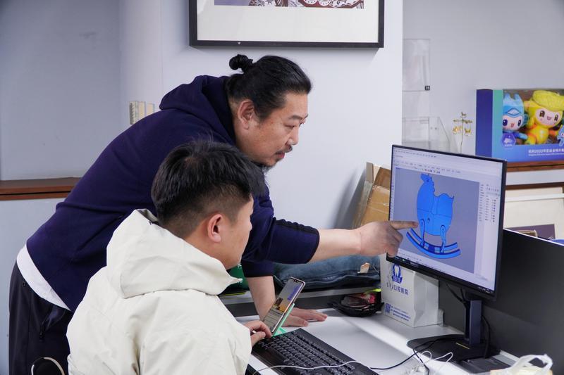 图为,李向宇指导设计师创作“唐富贵”文创产品