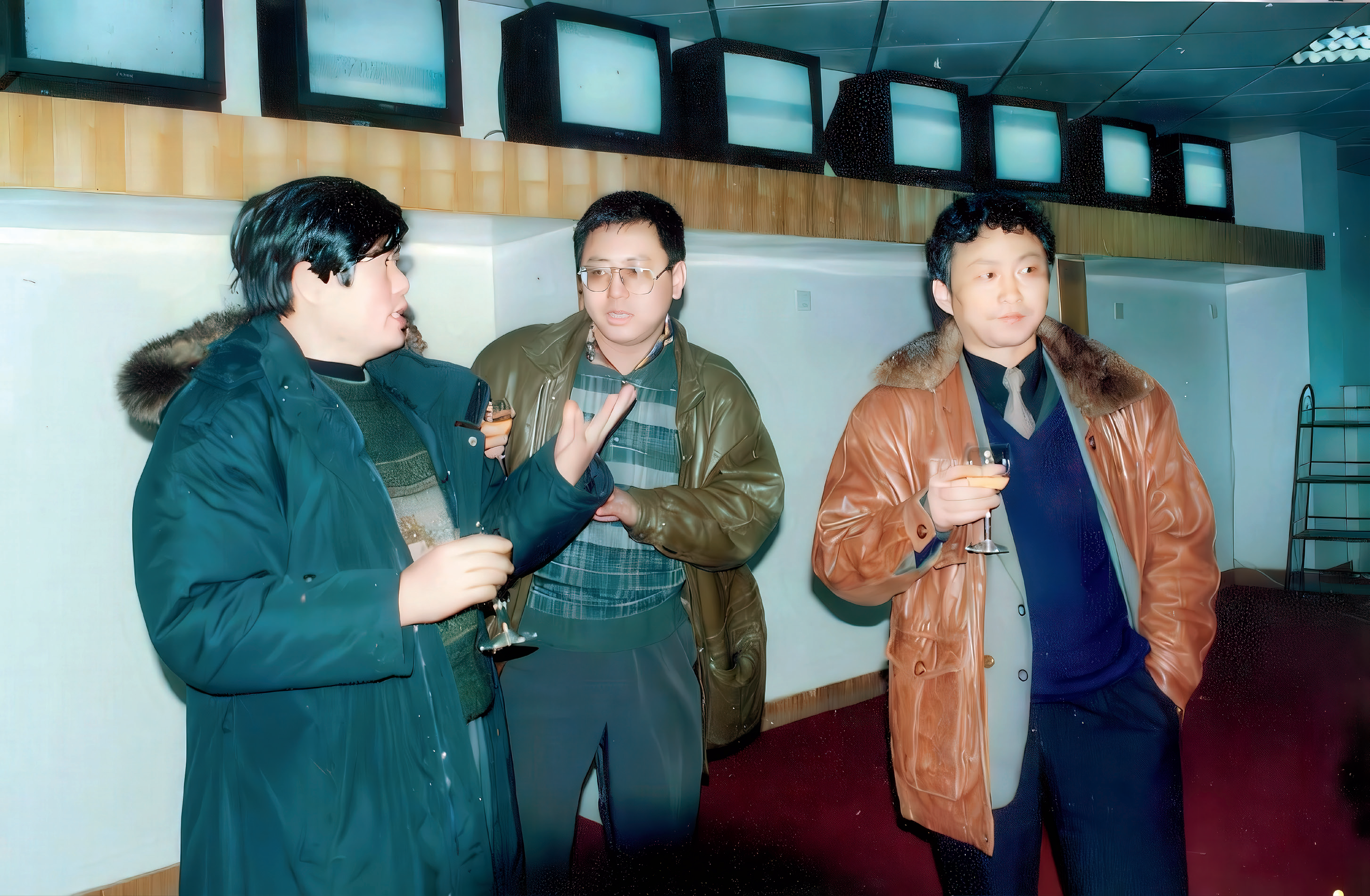 图说:1995年12月18日湖南经济电视台试播,魏文彬(右一)、欧阳常林(左一)、吕焕斌(中)在报道部看完《经视新闻》首次直播后举香槟庆祝
