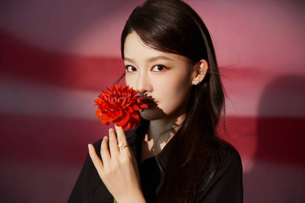 李沁手拿花束，眼神故事感满满。