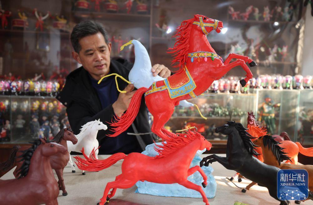 1月16日,在山东省临沂市沂南县红石寨非物质文化遗产博物馆,面塑艺人左安胜在创作面塑作品“赤马踏春”。新华社发(王彦冰 摄)