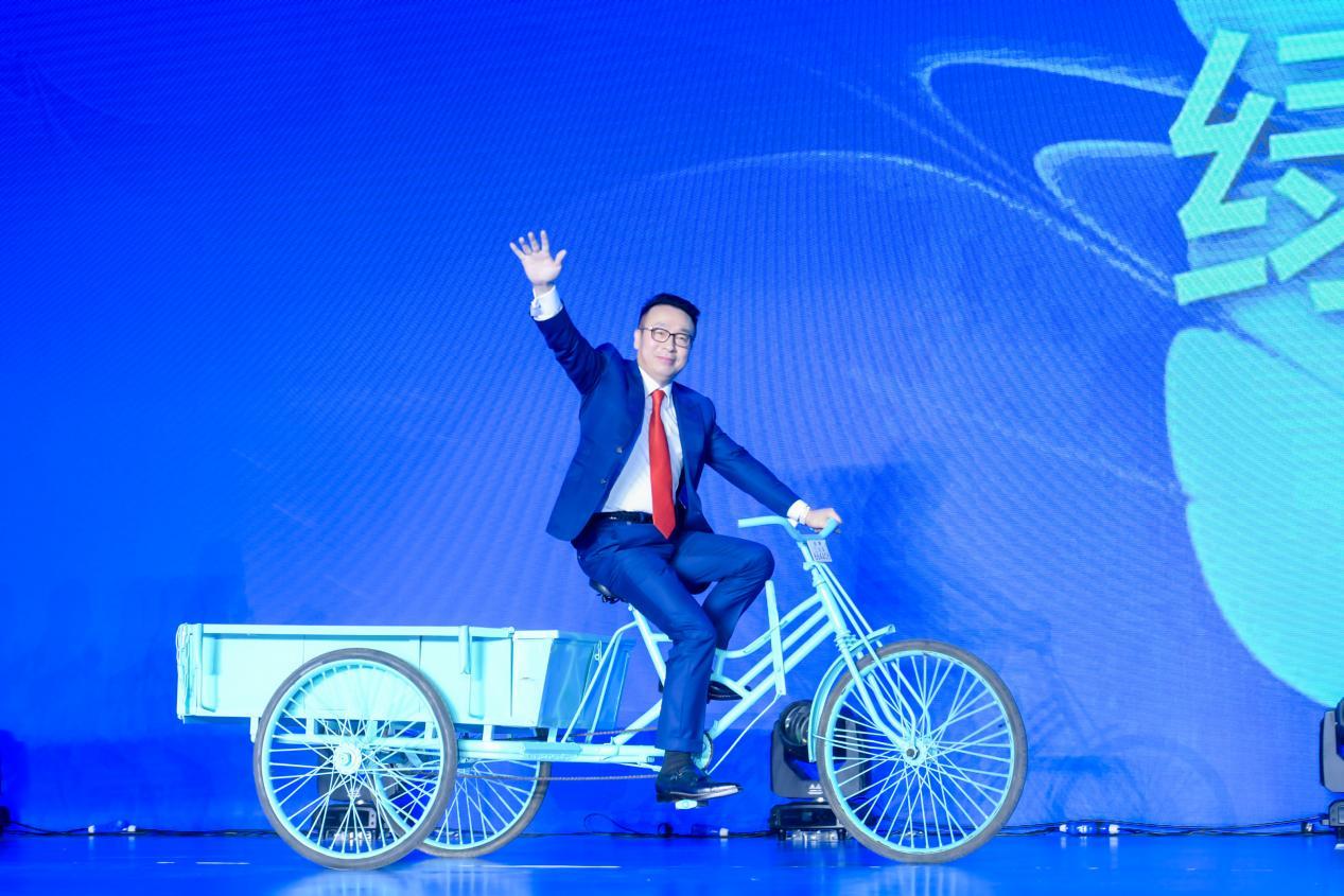 ▲绿叶科技集团十周年庆典上,徐建成骑三轮车登上舞台