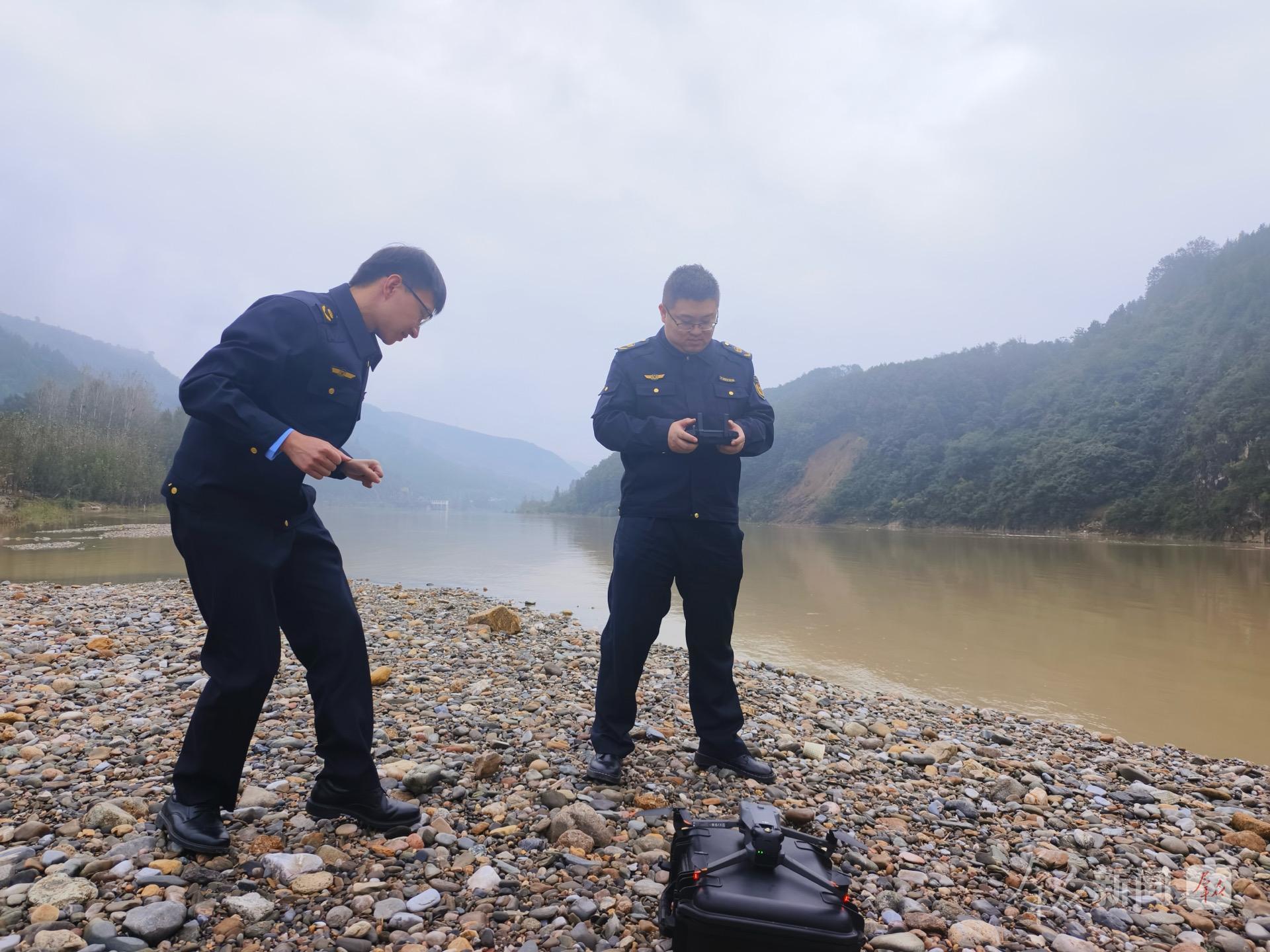 商南县环保局执法队队长段鑫宇和同事们正在用无人机查看河岸