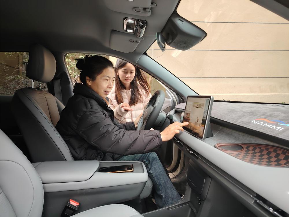 奉新县赤岸镇的消费者正在试乘新能源汽车，了解2026年消费品以旧换新补贴新政策。 （温军霞 邓建刚 摄）