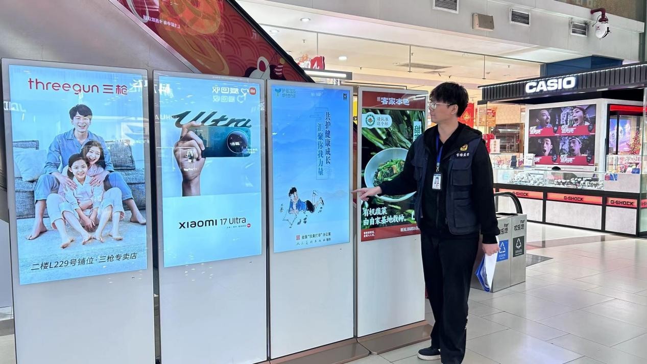 执法人员在商场开展绿书签宣传活动。