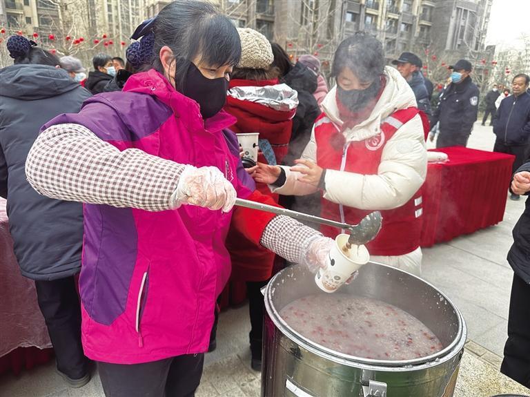 砂坪村社区在易大天地小区给居民送腊八粥