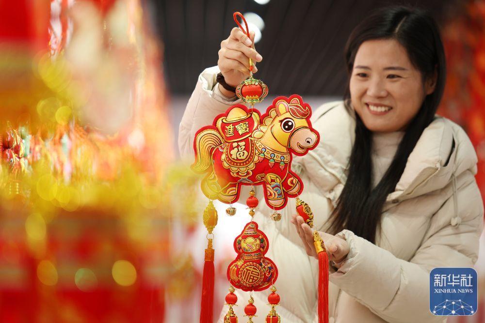 1月15日,在山东省临沂市郯城县红花镇一家中国结饰品加工企业,工作人员展示马年挂件。新华社发(张春雷 摄)