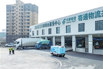 工作人员操作无人驾驶快递车。