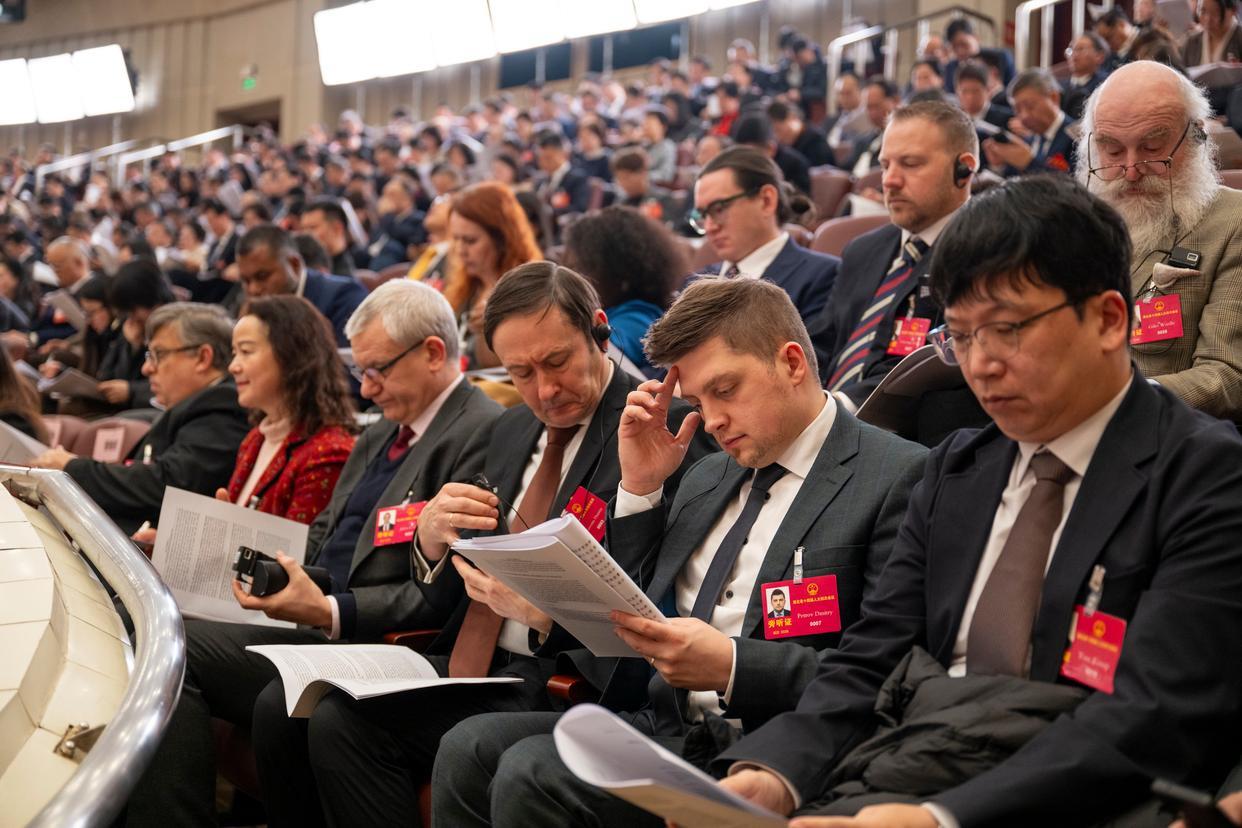 外籍人士正在湖北两会现场阅读政府工作报告。新华社记者 伍志尊 摄