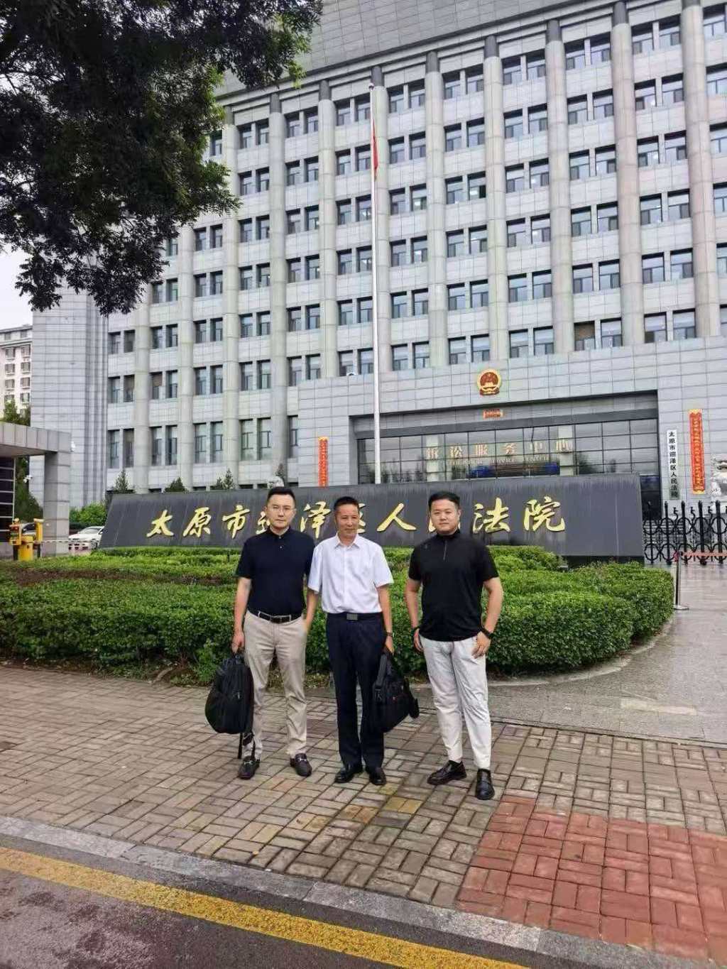 张宝财孙子张坤宇(右一)和辩护律师李金宝(左一)、李长青(中)。