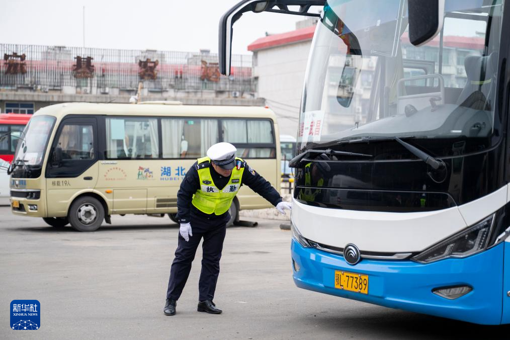 1月29日,在湖北省武汉市宏基长途客运汽车站,武汉交警对长途汽车进行安全检查。新华社记者 伍志尊 摄