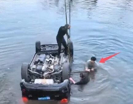 赖跃龙在冰冷河水中尝试开车门。