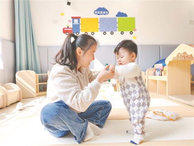 青山湖区托育服务中心里，保育员在锻炼孩子走路。 本报全媒体记者 陈 璋摄