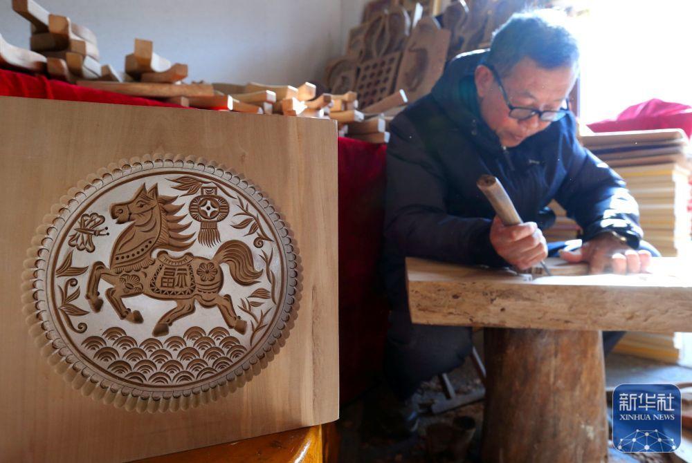 1月17日,在青岛市即墨区,山东省青岛市级非物质文化遗产代表性传承人王承厚创作马题材的榼子。新华社发(梁孝鹏 摄)