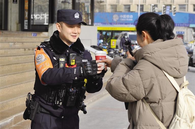 记者将热茶送给正在巡逻的民警