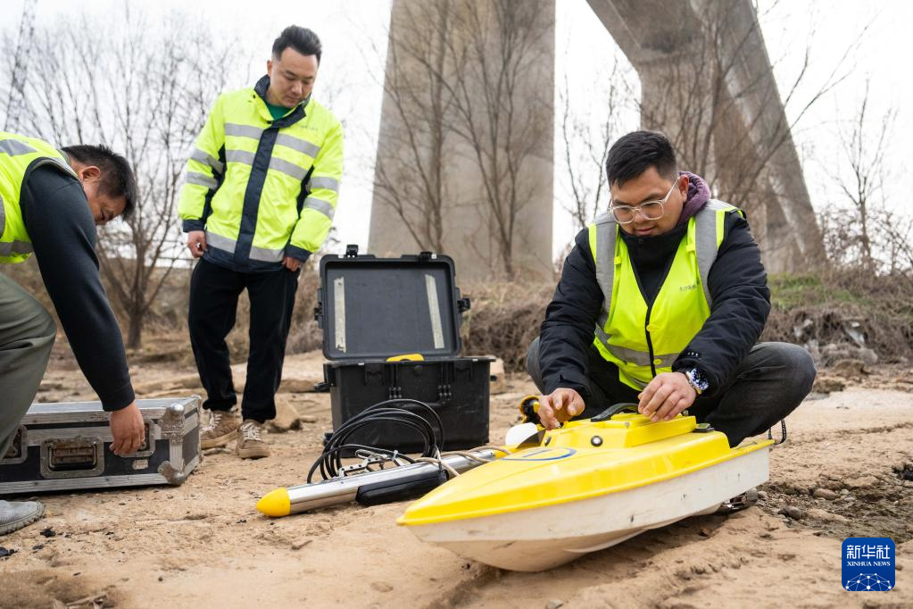1月29日，在沪昆高铁湘江特大桥下，铁路工人组装无人测量船准备检测河床情况。新华社记者 陈思汗 摄