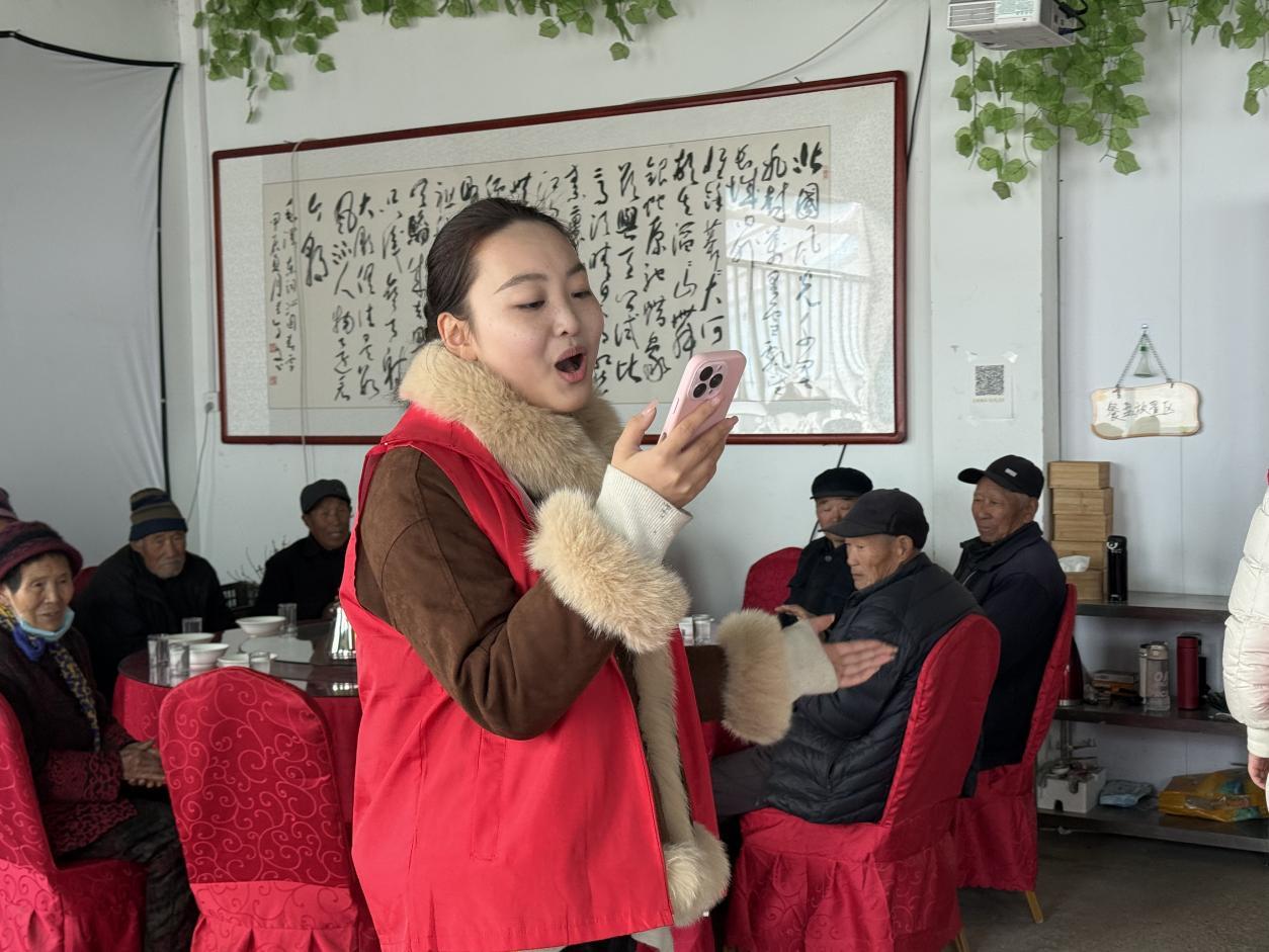 团队成员范阳在餐厅给老人唱歌