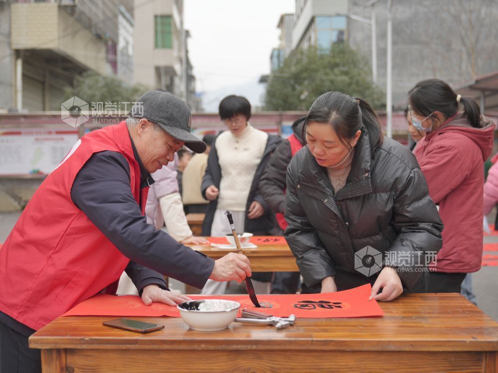 2026年2月4日,在江西省萍乡市芦溪县芦溪镇更田村,党员志愿者和书法爱好者为村民写春联。