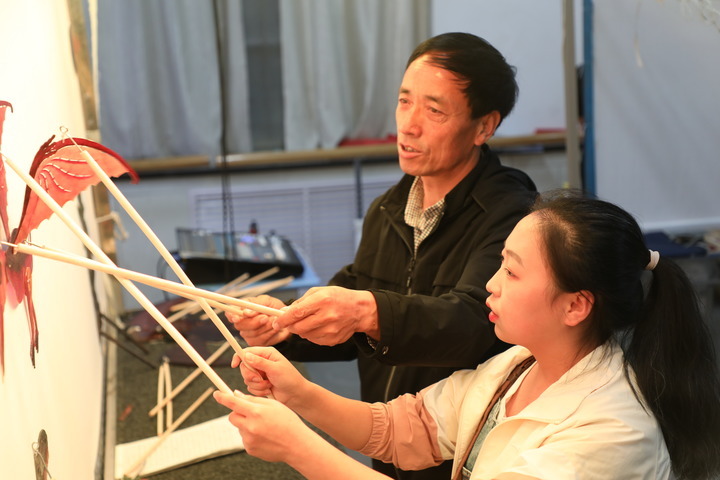 敬登琨和学生在课堂上一起表演皮影　新华社记者　张睿　摄