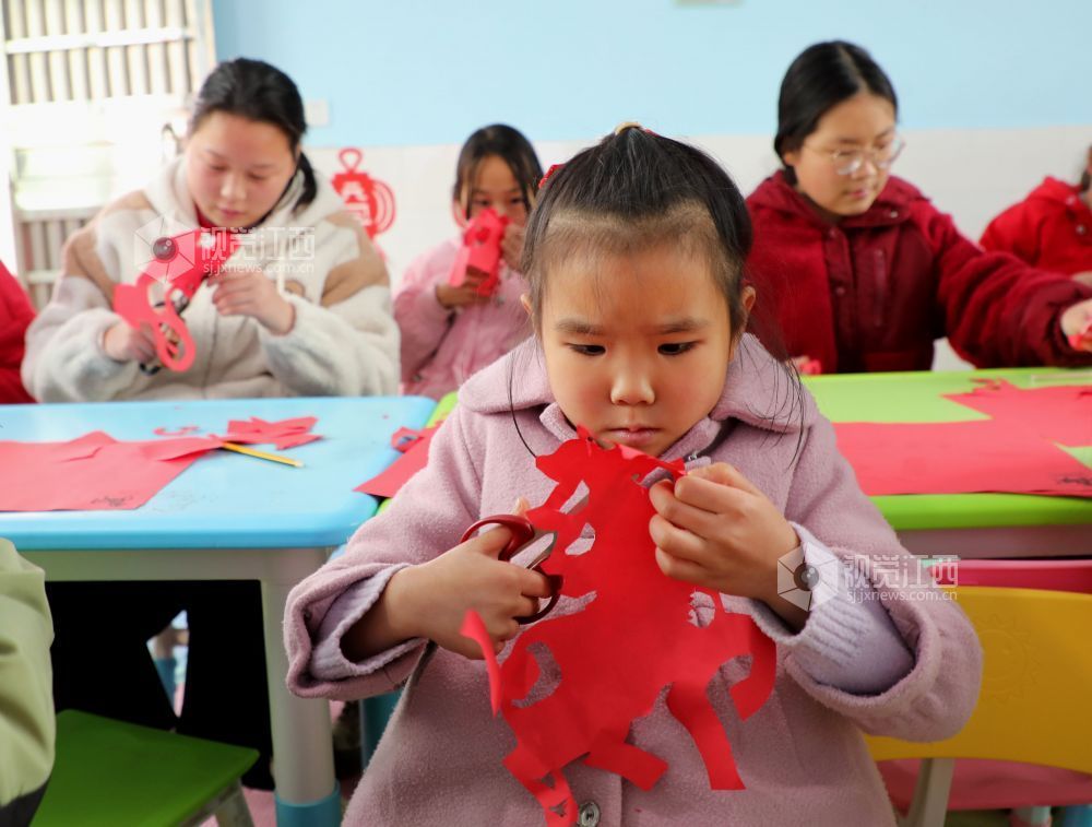 2026年1月31日,江西省吉安市泰和县螺溪镇建丰村童心港湾,小朋友正在体验剪纸,乐享寒假时光。