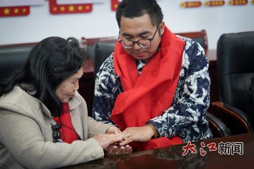 母子的手紧紧地握在一起。（图片由李磊、全媒体记者徐国亮摄）