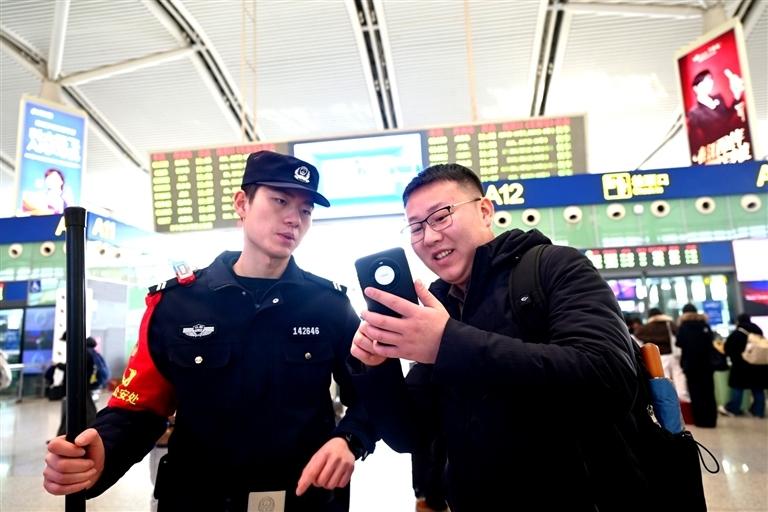 2月2日，南昌铁路公安处民警在南昌西站候车大厅内为旅客答疑解惑。江西日报全媒体首席记者 李 劼摄