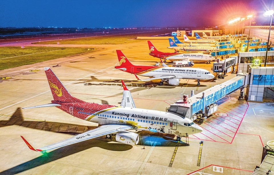 运城盐湖国际机场机坪上航空客机依次排开，廊桥相连、灯光辉映。