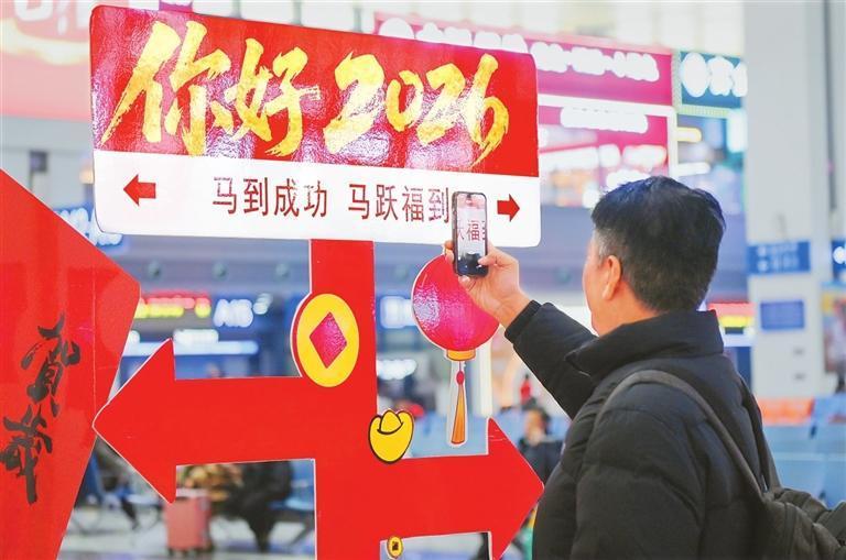 一位旅客对着“你好2026”的祝福牌拍照，将美好的祝愿定格在镜头里。