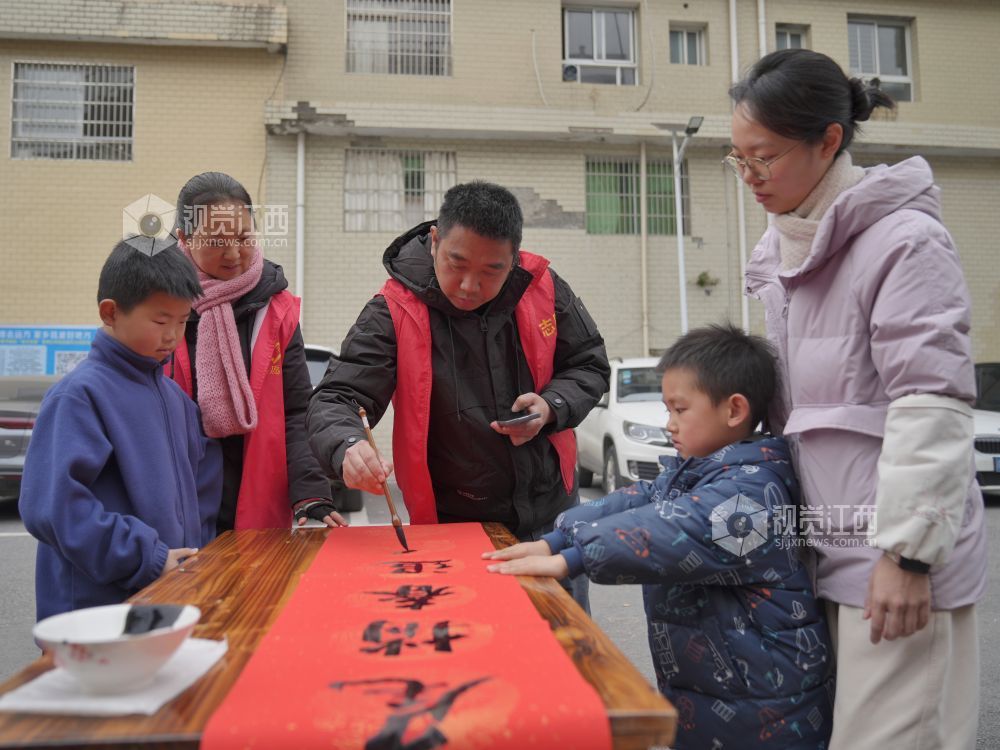 2026年2月4日,在江西省萍乡市芦溪县芦溪镇更田村,党员志愿者和书法爱好者为村民写春联。