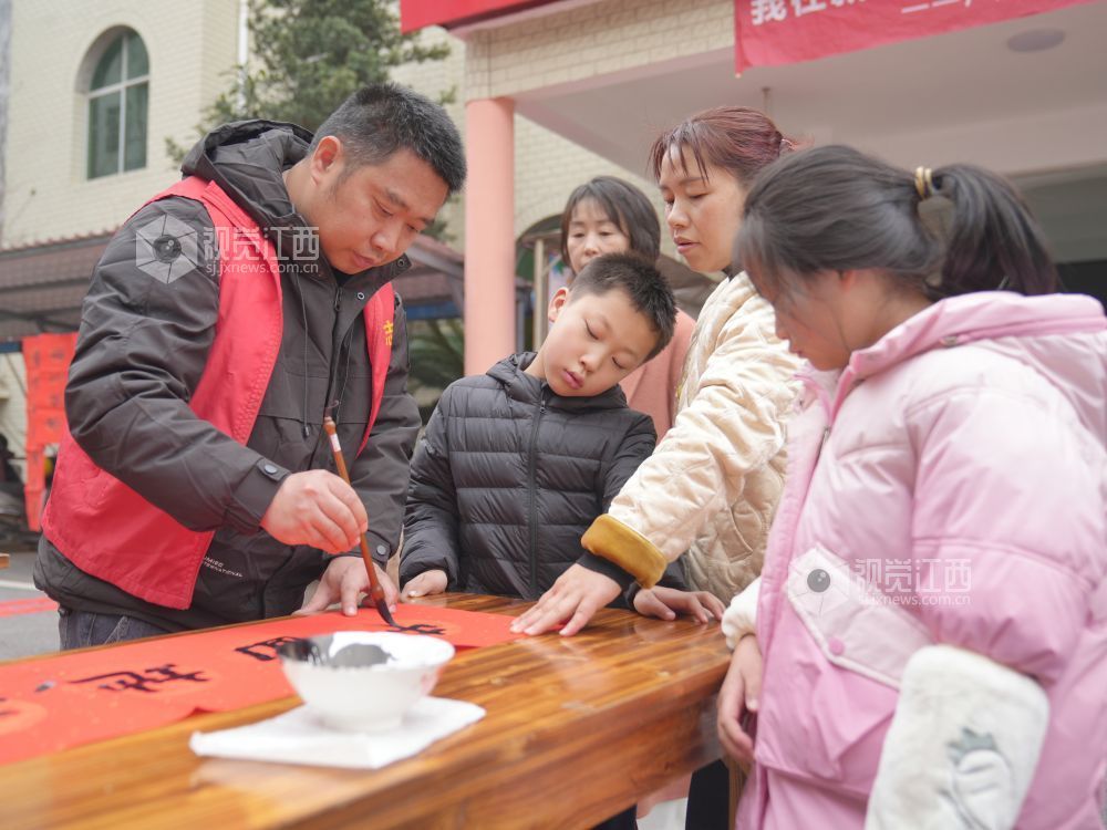2026年2月4日,在江西省萍乡市芦溪县芦溪镇更田村,党员志愿者和书法爱好者为村民写春联。