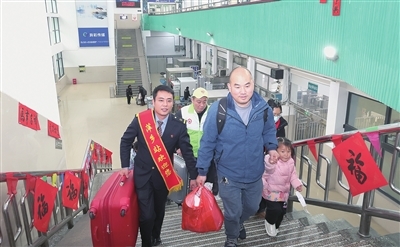 图为1月31日，在萍乡火车站，工作人员和青年志愿者帮助旅客搬运行李。