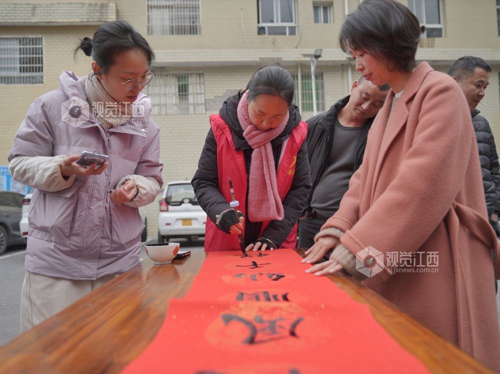 2026年2月4日,在江西省萍乡市芦溪县芦溪镇更田村,党员志愿者和书法爱好者为村民写春联。