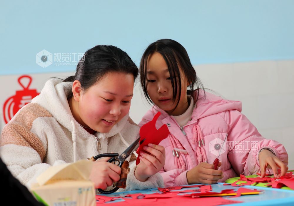 2026年1月31日,江西省吉安市泰和县螺溪镇建丰村童心港湾,小朋友正在体验剪纸,乐享寒假时光。