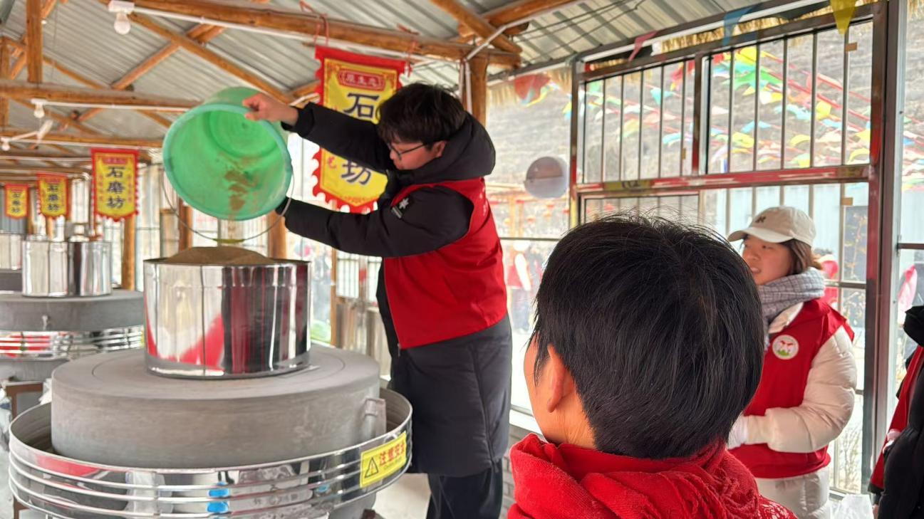 图 团队成员田世豪在体验磨面粉