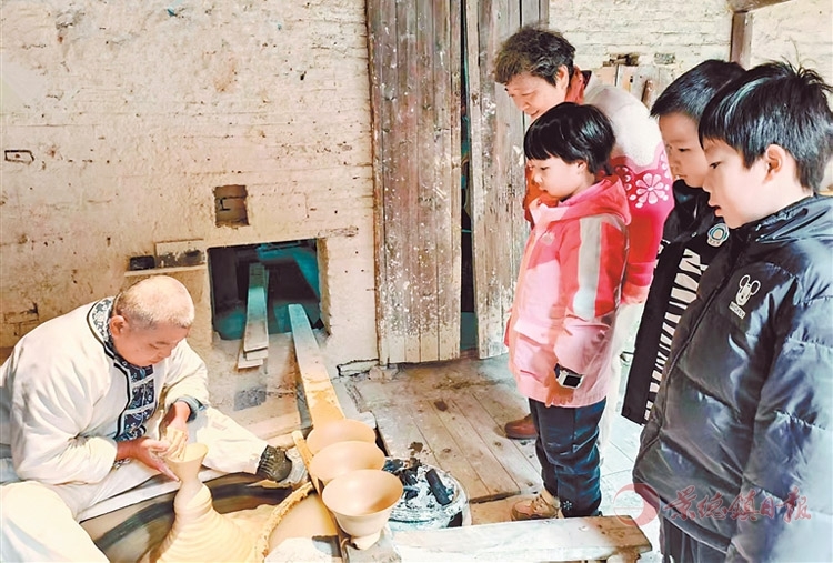 景德镇古窑民俗博览区内，游客正在围观尹盛亮拉坯。