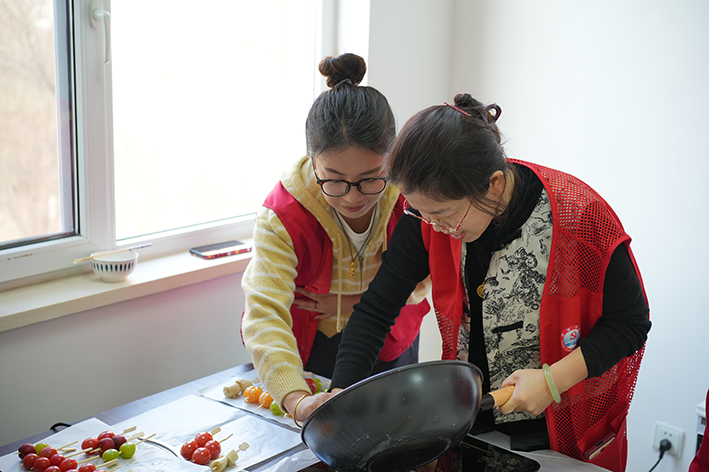 图为活动现场新裕路社区志愿者制作糖葫芦（朱李男摄）