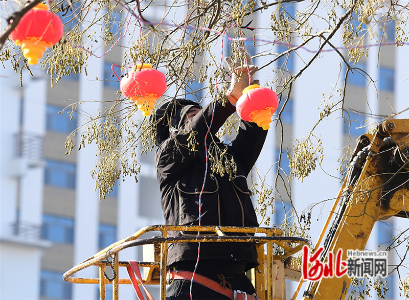 2月3日，工人师傅在张家口市怀来县街头悬挂灯笼。
