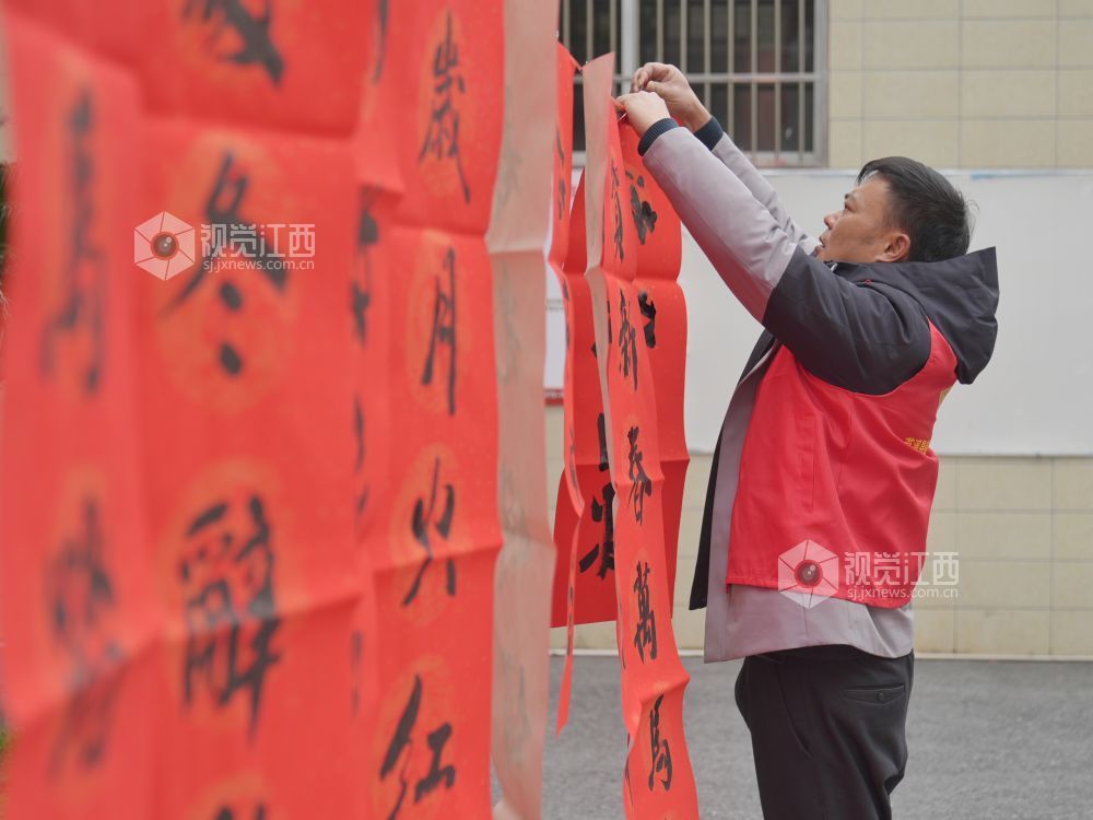 2026年2月4日,在江西省萍乡市芦溪县芦溪镇更田村,党员志愿者和书法爱好者为村民写春联。