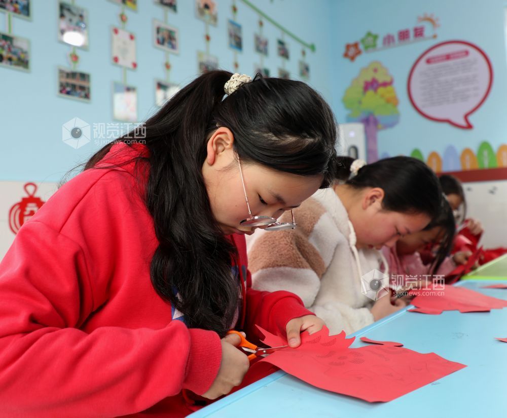 2026年1月31日,江西省吉安市泰和县螺溪镇建丰村童心港湾,小朋友正在体验剪纸,乐享寒假时光。