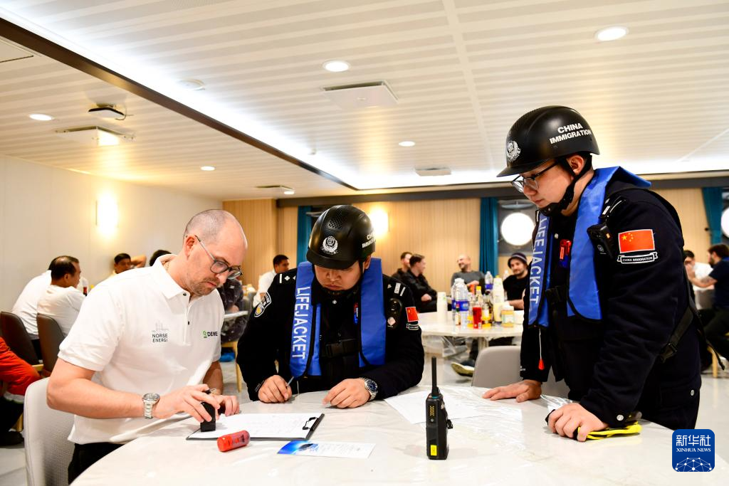 2月3日，在中集来福士山东烟台建造基地，山东出入境边防检查总站烟台边检站来福士警务室民警和比利时风电安装船船长签署船长告知书。新华社记者 郭绪雷 摄